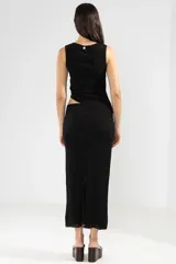 Top negro sin mangas con detalle de abertura en la cintura. Hecho en Italia.