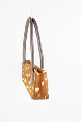 Cartera tipo baguette color negro con textura efecto cocodrilo, diseño alargado, doble asa de mano y cierre superior.