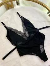 Body negro de lycra con encaje en escote y laterales, breteles finos regulables y gancho en la cintura.