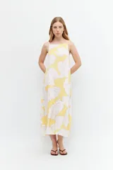 Maxi vestido amarillo con estampado floral blanco y rosa, de tirantes finos y corte holgado.