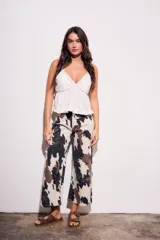Pantalón de jean tiro medio, corte wide leg, con estampado que simula manchas de vaca en tonos beige, marrón y negro.