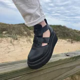 Zapatos de cuero con plataforma alta en tonos marrones y beige, diseño de tiras cruzadas en el empeine y laterales abiertos.
