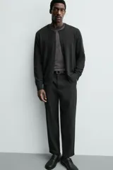 Pantalón de corte regular fit, color negro, confeccionado en tejido elástico. Presenta cintura elástica, cierre frontal con cremallera y botón, bolsillos laterales y bolsillos traseros de vivo.