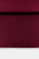 Pañuelo rectangular de color marrón oscuro, con diseño liso y terminaciones con flecos deshilachados en los extremos.