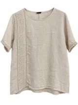 Blusa beige de manga corta y cuello redondo, con delicados detalles de alforzas y bordados verticales en el frente, y terminaciones desflecarse en las mangas.
