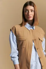 Camisa de manga larga a rayas verticales blancas y azules, con cuello camisero, cartera frontal con botones y calce relajado.