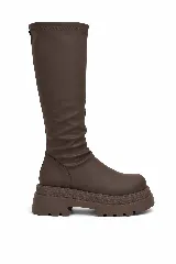 Bota bucanera de caña alta color marrón, con diseño de efecto arrugado en la caña y suela track de plataforma gruesa.