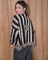 Buzo de punto holgado con diseño de rayas verticales en negro y beige, presenta una estrella grande en la espalda y terminaciones en color tostado en puños y ruedo.
