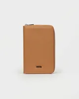 Funda porta pasaporte Prüne de cuero sintético negro con cierre de cremallera y logo grabado en la parte inferior.