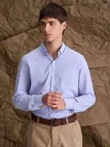 Camisa de manga larga con cuello button down, cierre frontal con botones y bolsillo en el pecho. Presenta un diseño de microestampado sutil en tono azul claro.
