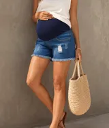 Short de jean azul lavado con detalles gastados y roturas, con faja abdominal de algodón elastizado para maternidad y terminación desmechada en las piernas.