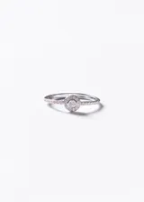 Anillo de plata 925 con diseño fino y elegante, adornado con zirconias incrustadas en el aro y un motivo circular central pavé.