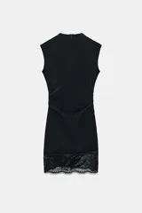 Vestido corto de tejido elástico, sin mangas, con cuello redondo y detalle de frunces en la cintura. Presenta un borde inferior con encaje combinado a tono.