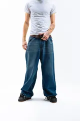 Pantalón de jean azul oscuro con efecto desgastado, corte mega baggy de tiro alto y pierna ancha. Presenta cinco bolsillos y botones personalizados.