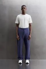 Pantalón jogger relaxed fit Zara Athleticz de tejido técnico compacto elástico con mezcla de algodón. Presenta cintura elástica ajustable con cordón, bolsillos laterales en la cadera, bolsillo trasero con cierre de cremallera, bajo ajustable con elástico y detalle de logo estampado en la pernera.