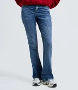 Pantalón de jean corte flare, con cintura media, cierre frontal con cremallera y botón, y diseño clásico de cinco bolsillos.