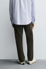 Pantalón de corte recto confeccionado en tejido de algodón con elasticidad. Presenta diseño de cinco bolsillos, cierre frontal con cremallera y botón.