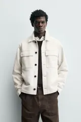 Sobrecamisa regular fit color verde oscuro, confeccionada en tejido efecto ante. Cuenta con cuello solapa, manga larga con puño abotonado, bolsillos de plastrón con solapa en el pecho y bolsillos de vivo en la cadera. El cierre es frontal con botonadura.