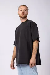 Remeron de algodón rústico con efecto de lavado gastado, corte oversize, cuello redondo y mangas cortas con terminaciones al corte.