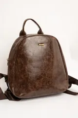Mochila de cuero sintético marrón con efecto craquelado, asa superior y placa metálica frontal con el logo de la marca.
