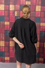 Camisa negra con pequeños apliques brillantes, corte oversize y mangas largas.