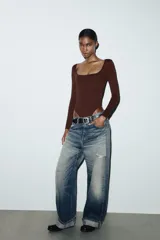 Body de manga larga con escote cuadrado, confeccionado en tejido elástico con cierre inferior mediante botones a presión.