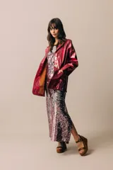 Blazer de cuero color celeste metalizado, con solapas, cierre con broches tipo tanca de madera y puños con detalle de piel sintética marrón.