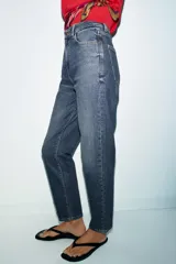 Jeans de tiro alto con corte mom fit, cinco bolsillos y cierre frontal con cremallera y botón.