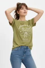 Remera de algodón verde militar, de manga corta con vuelta en las mangas, cuello redondo y calce holgado. Cuenta con estampado frontal en color blanco con diseño de rosas, estrellas y texto.