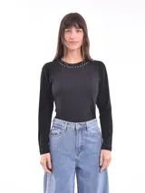 Remera negra de manga larga con cuello redondo y detalle de pequeñas tachas plateadas alrededor del cuello.