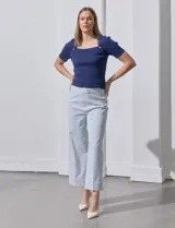 Pantalón wide leg con estampado de rayas verticales celestes y blancas, pretina con botón, bolsillos simulados en la parte delantera y ruedo con dobladillo.