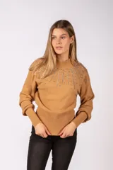 Sweater de punto color camel con cuello alto y detalle de pedrería brillante en la parte superior delantera. Presenta mangas largas con puños acanalados y cintura ajustada con el mismo tejido acanalado.