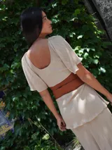 Vestido largo de dos piezas color lila con rayas verticales. El top es de corte cuadrado con mangas cortas acampanadas y elástico en la cintura. La falda es larga con volados y detalles de cuero.