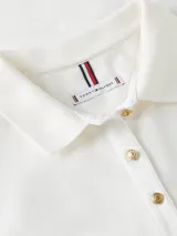 Chomba de piqué blanca de corte slim, con cuello polo, cartera de cuatro botones y mangas cortas abullonadas. Presenta el logo de la marca bordado en el pecho.