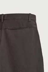 Pantalón barrel fit de corte ancho color marrón, confeccionado en mezcla de algodón y lino. Presenta bolsillos frontales, bolsillos traseros de vivo y cierre frontal con cremallera y botón.