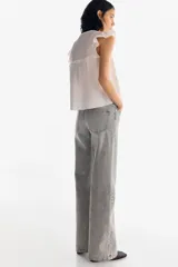 Pantalón de jean gris de tiro alto, corte wide leg y cinco bolsillos.