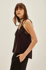 Top de crepe viscosa color verde azulado, con escote en V adornado con encaje y bordados florales con lentejuelas. Posee breteles finos regulables y elástico en la espalda.