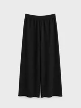 Pantalón de tejido de punto color negro, con corte amplio y relajado, cintura elástica y ruedo con terminación simple.