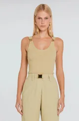 Musculosa canelada de color beige con calce ajustado, escote redondo y detalles de hebillas doradas en los tirantes.