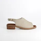 Sandalias amarillas de cuero con puntera abierta, taco bajo de madera y tira trasera con hebilla.