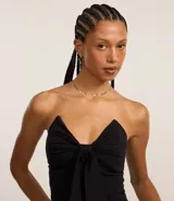 Blusa sin breteles negra confeccionada en bengalina, con escote triangular y lazo aplicado.