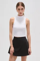 Falda mini de corte evasé en color negro, confeccionada en tejido de poliéster con cintura alta.