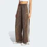 Pantalón Adidas Originals de pierna ancha, confeccionado en satén con estampado animal print de leopardo. Cuenta con cintura elástica, las clásicas tres tiras blancas en los laterales y el logo del trifolio bordado en el frente.