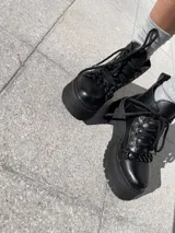 Botas negras de ecocuero con detalle de cadena en la parte delantera y taco de 6cm.