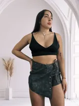 Short pollera gris con efecto gastado, cierre lateral con cremallera, cordón ajustable en la cintura y detalle de tachas plateadas en el frente.