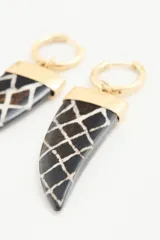 Aro de argolla dorada con dije colgante en forma de cuerno, color negro con patrón de red blanco y detalle dorado en la parte superior.