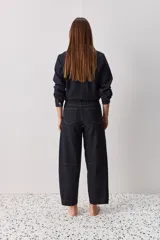 Jean de corte barrel, tiro alto, con silueta amplia que se estrecha hacia el tobillo. Confeccionado en denim azul oscuro con costuras a contratono.