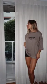 Remera color visón de algodón, corte holgado y mangas cortas. Estampa frontal con texto "Manhattan New York 1998".