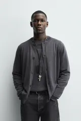 Cárdigan de punto con lana, de corte regular fit, cuello redondo y manga larga. Presenta cierre frontal con botones y acabados en rib en puños y bajo.