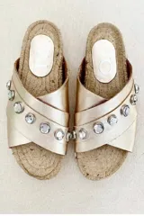 Sandalia dorada con tiras cruzadas y apliques de strass. Base de yute.
